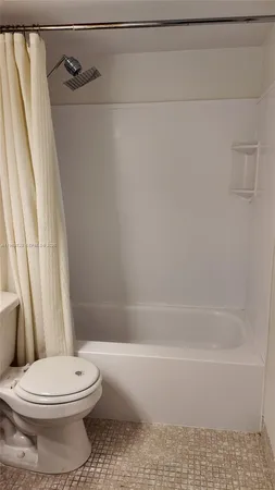 a view of a room that has wooden floor and cabinets