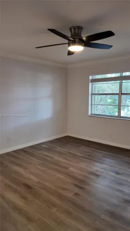 en empty room with wooden floor fan and windows