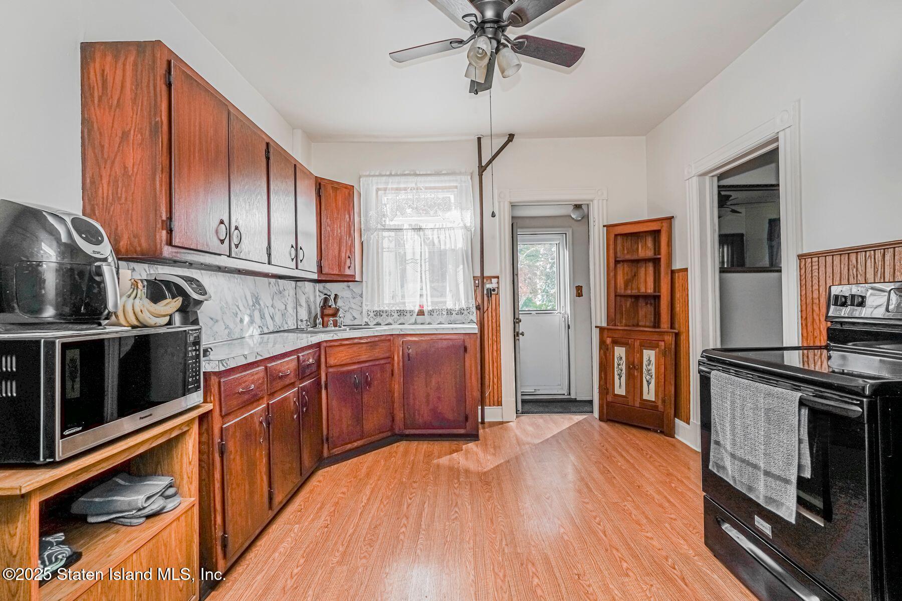 5300 Amboy Road Staten Island, NY 10312 - Photo 11 of 32 a kitchen with stainless steel appliances granite countertop a refrigerator a stove top oven a sink and dishwasher with wooden floor