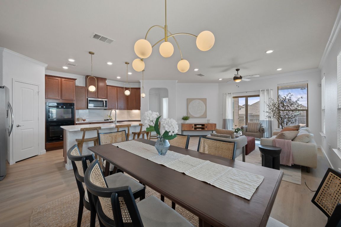 709 Screech Owl Drive Pflugerville, TX 78660 - Photo 1 of 1 a view of a dining room and livingroom with furniture wooden floor and a chandelier
