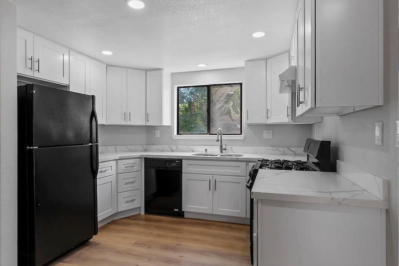 34 West 7th Street, Unit E Tracy, CA 95376 - Photo 1 of 1 a kitchen with a sink a refrigerator and a stove