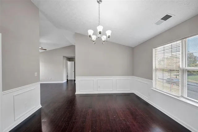 a living room with stainless steel appliances kitchen island a fireplace and wooden floor