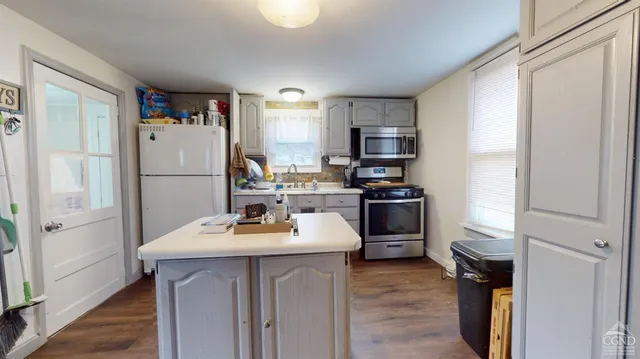 a kitchen with a sink refrigerator and microwave