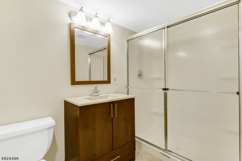 250 South Ridgedale Avenue, Unit 4 Florham Park, NJ 07932 - Photo 14 of 15 a bathroom with a toilet a sink and mirror