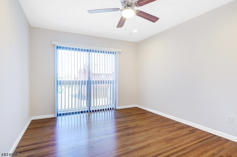 250 South Ridgedale Avenue, Unit 4 Florham Park, NJ 07932 - Photo 6 of 15 an empty room with wooden floor fan and windows