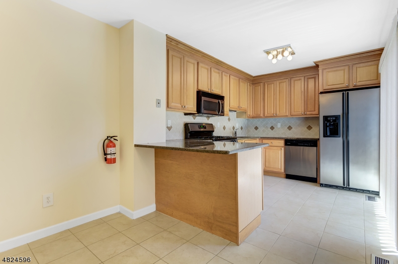 250 South Ridgedale Avenue, Unit 4 Florham Park, NJ 07932 - Photo 8 of 15 a kitchen with stainless steel appliances granite countertop a refrigerator a stove top oven a sink and dishwasher