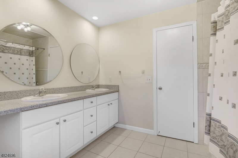 250 South Ridgedale Avenue, Unit 4 Florham Park, NJ 07932 - Photo 10 of 15 a bathroom with a granite countertop double vanity sink and a mirror