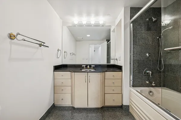 a bathroom with a sink a large mirror and a bathtub