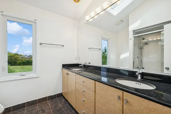 a bathroom with a granite countertop sink and a mirror