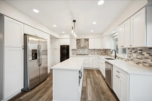 a kitchen with white cabinets and refrigerator