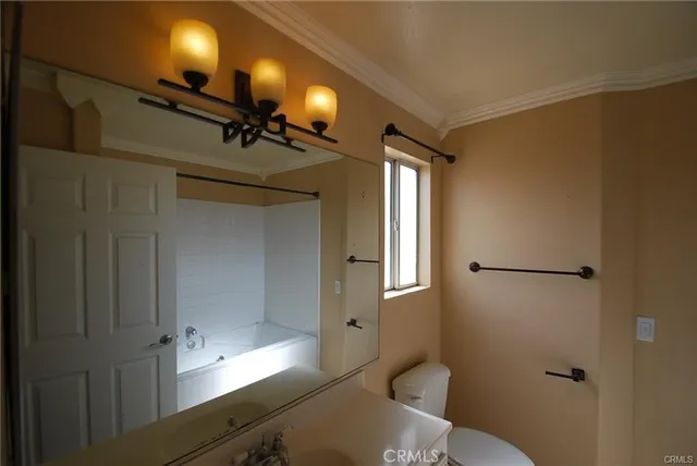 a bathroom with a sink mirror vanity and toilet