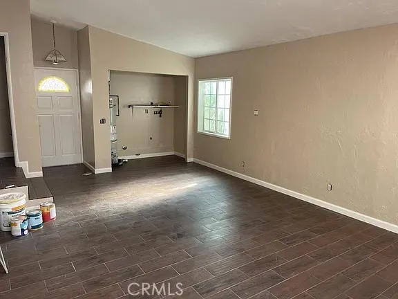 a view of empty room with wooden floor and window