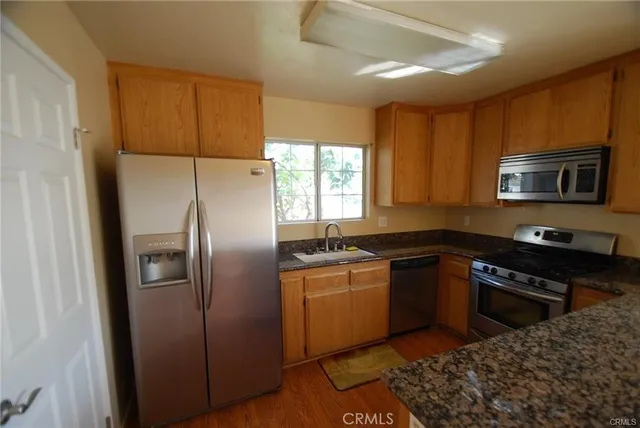 a kitchen with stainless steel appliances granite countertop a refrigerator a stove a sink and a microwave