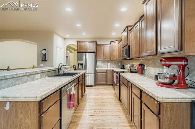 a kitchen with kitchen island granite countertop wooden cabinets and white appliances