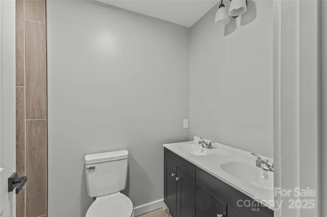 a bathroom with a sink mirror vanity and toilet