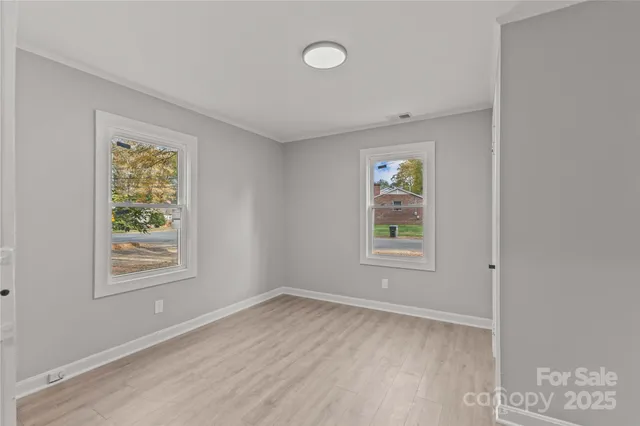 a view of an empty room with window and ceiling fan