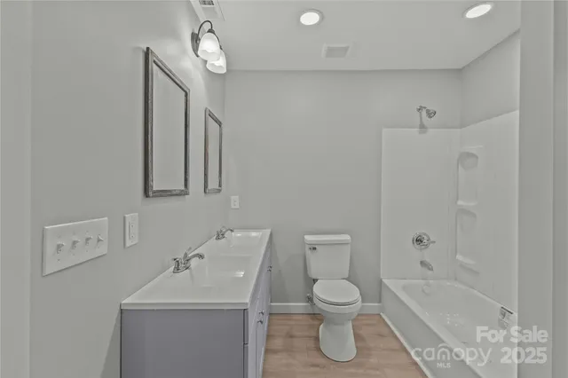 a bathroom with a toilet sink vanity tub and shower