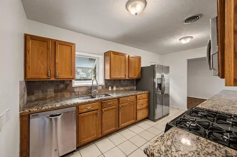 a kitchen with stainless steel appliances granite countertop a sink stove and refrigerator