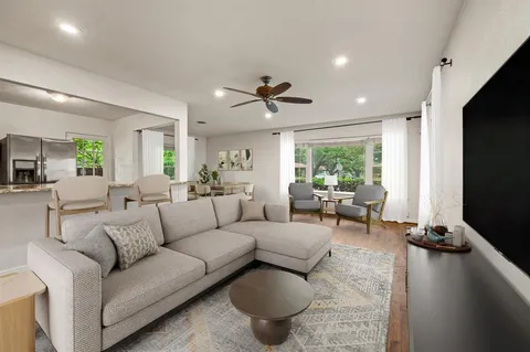 a living room with furniture a large window and a flat screen tv