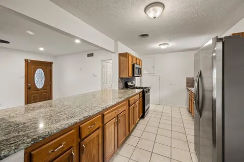 a kitchen with stainless steel appliances granite countertop a refrigerator and a sink