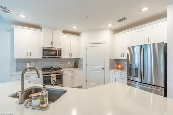 a kitchen with stainless steel appliances a stove sink and cabinets
