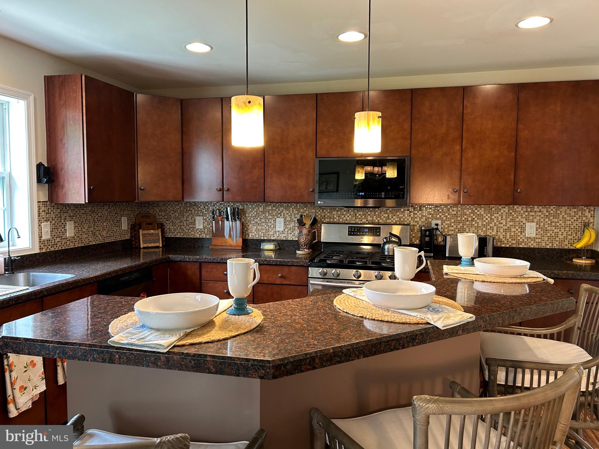 20346 Cool Spring Road Milton, DE 19968 - Photo 25 of 67 a kitchen with granite countertop a stove a sink a refrigerator dining table and chairs