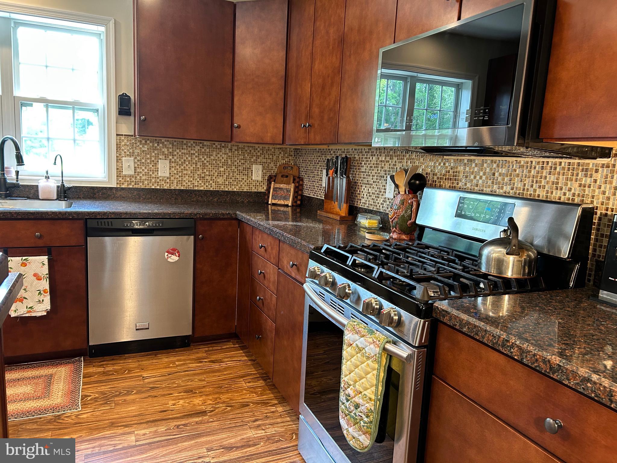 20346 Cool Spring Road Milton, DE 19968 - Photo 27 of 67 a kitchen with granite countertop a stove top oven sink and cabinets