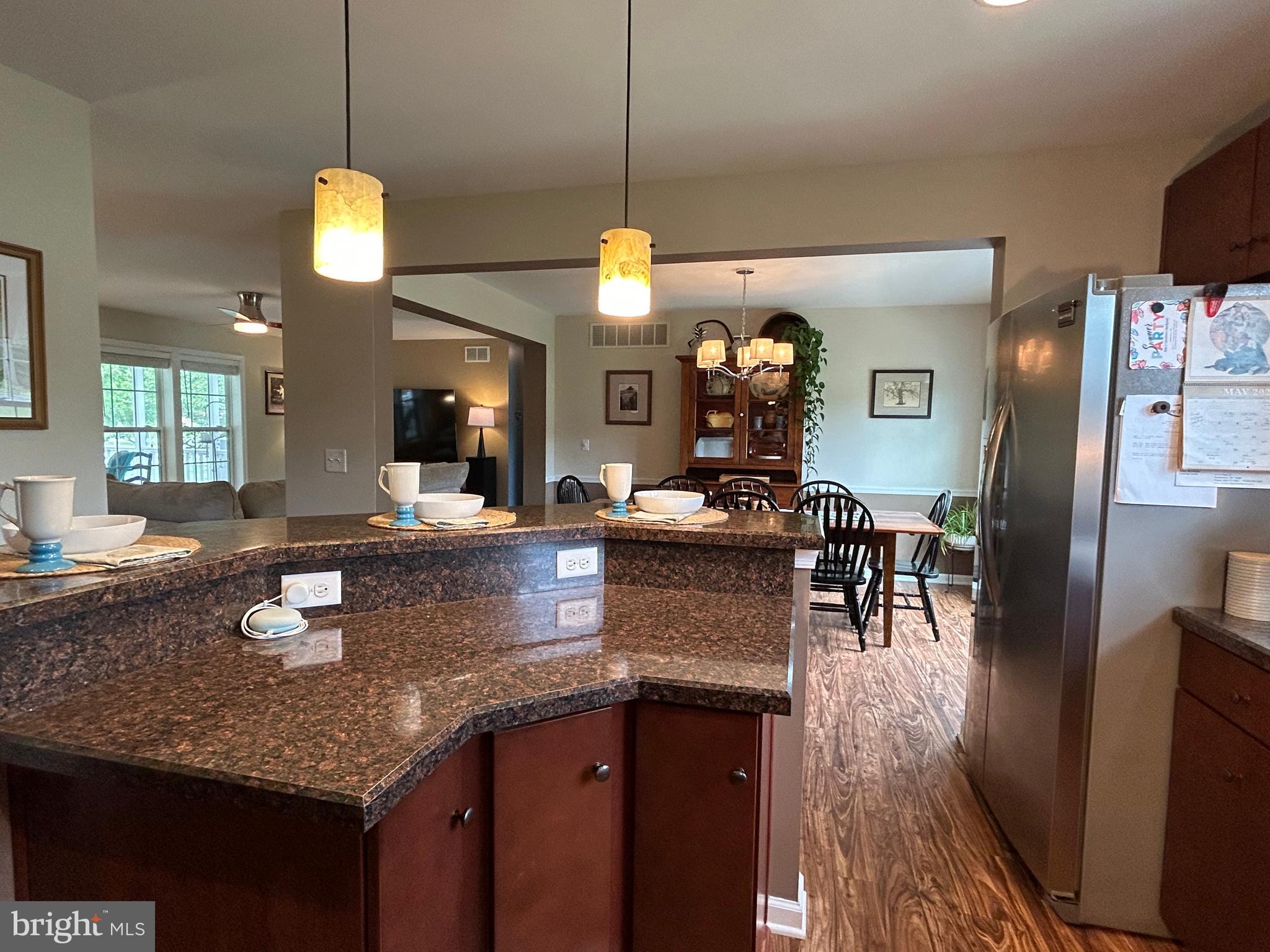 20346 Cool Spring Road Milton, DE 19968 - Photo 31 of 67 a kitchen with granite countertop kitchen island stainless steel appliances a dining table chairs sink and wooden floor