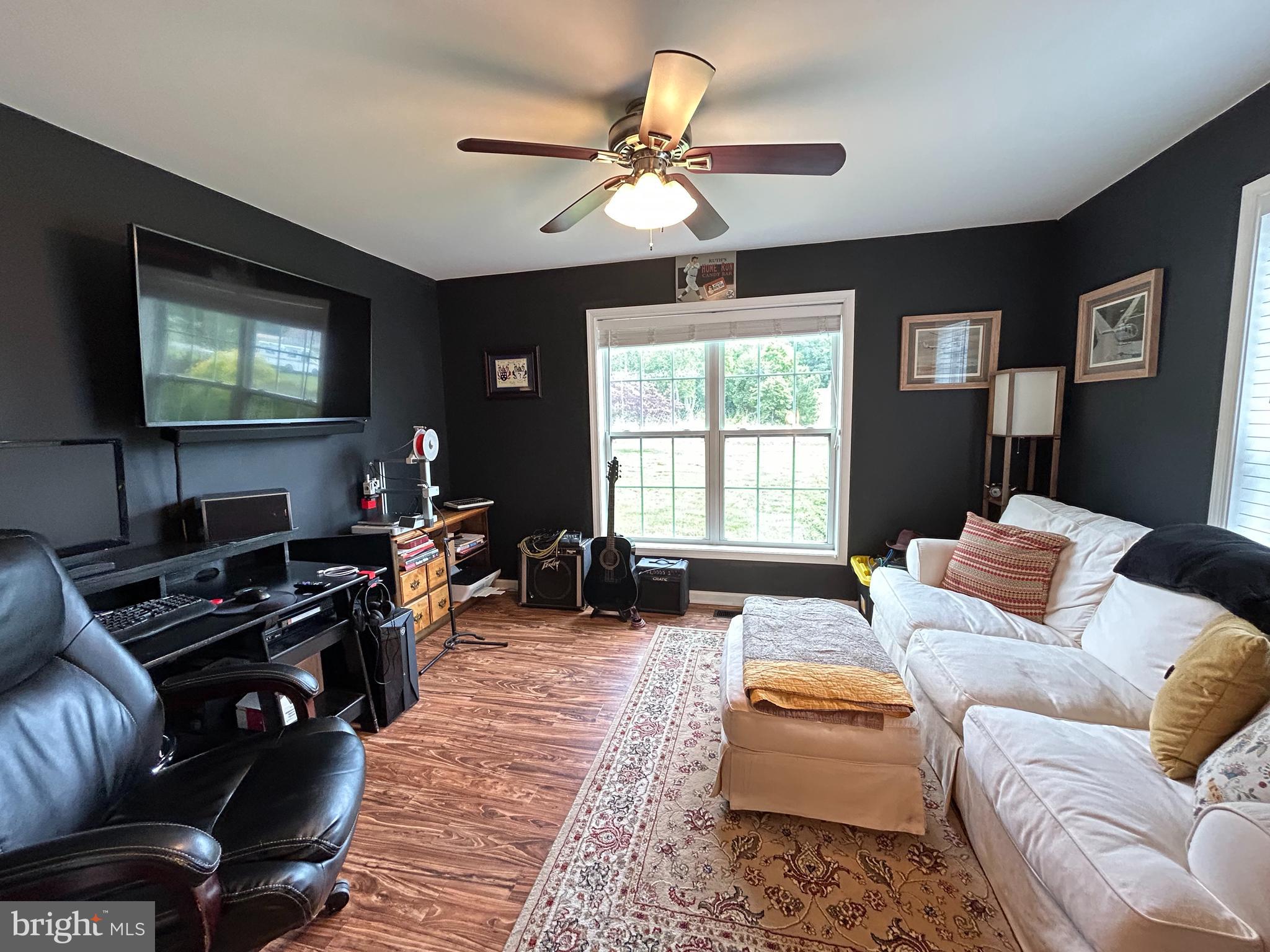 20346 Cool Spring Road Milton, DE 19968 - Photo 46 of 67 a living room with furniture a large window and a flat screen tv