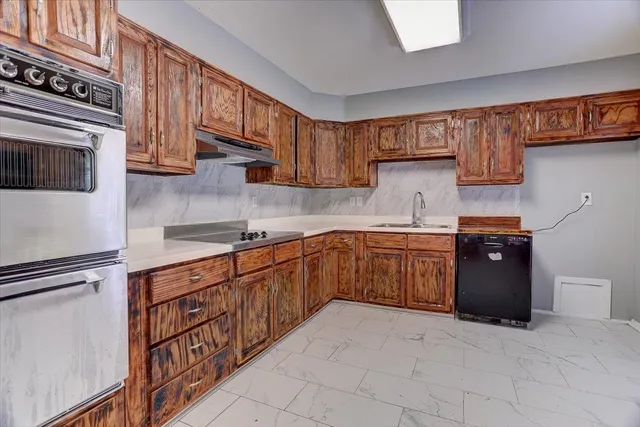 a kitchen with stainless steel appliances granite countertop a refrigerator and a stove top oven