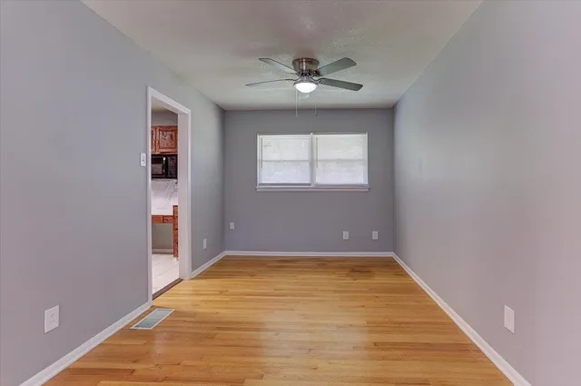 a view of an empty room with a chandelier fan