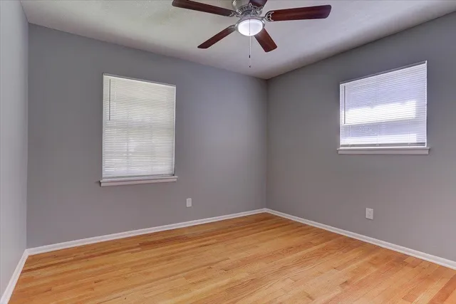a view of a room with wooden floor and windows
