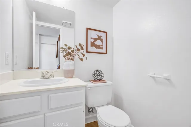 a bathroom with a granite countertop toilet sink and mirror