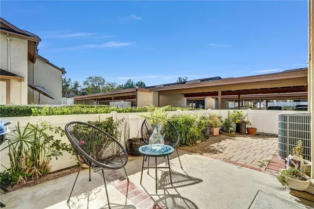 a view of a patio with table and chairs and potted plants with wooden floor and fence