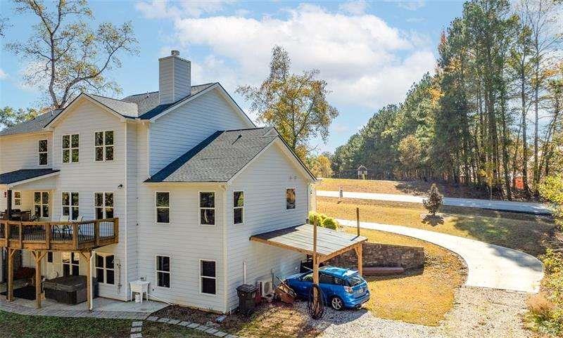 629 Dee Kennedy Road Winder, GA 30680 - Photo 4 of 67 a view of a white house with a large tree and plants