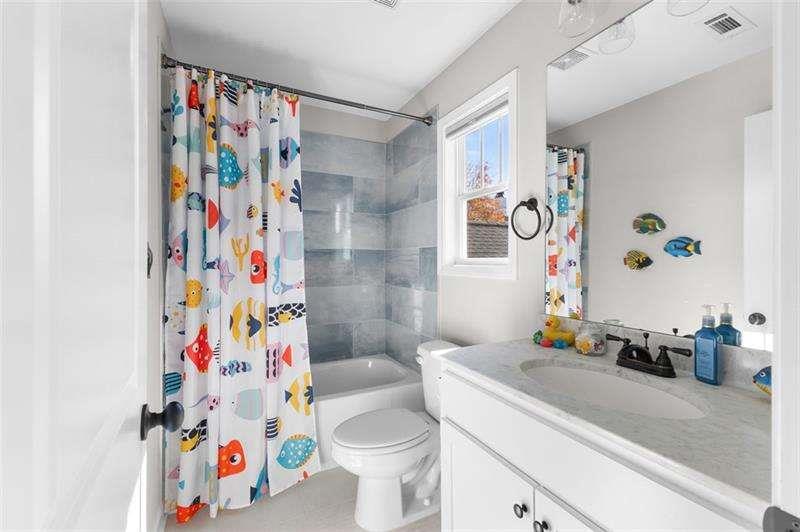 629 Dee Kennedy Road Winder, GA 30680 - Photo 42 of 67 a bathroom with a sink a toilet and a shower curtain