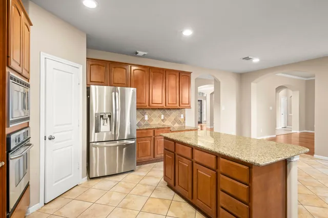 a kitchen with stainless steel appliances granite countertop a refrigerator and a sink