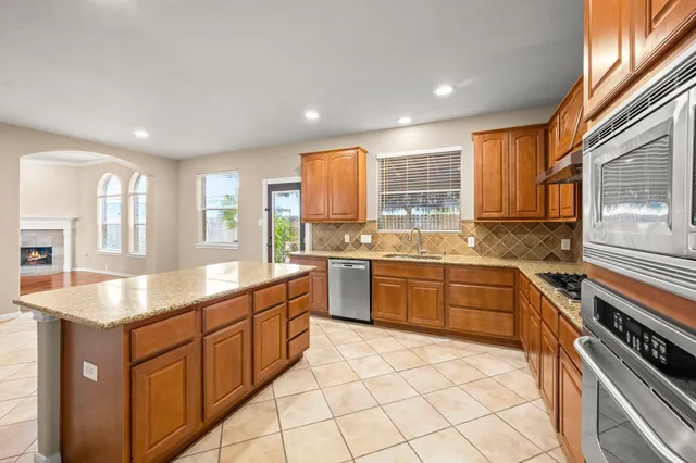 a kitchen with stainless steel appliances granite countertop a sink and a stove