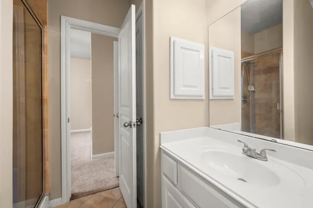 a bathroom with a granite countertop sink a mirror and a shower