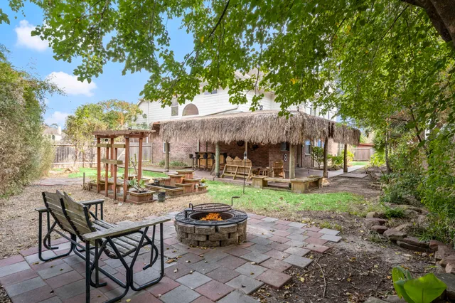 a view of a patio with table and chairs potted plants and large tree