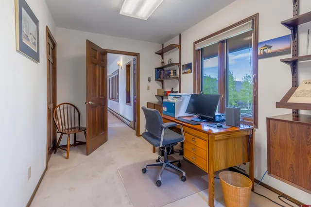 a view of a workspace with furniture and a window
