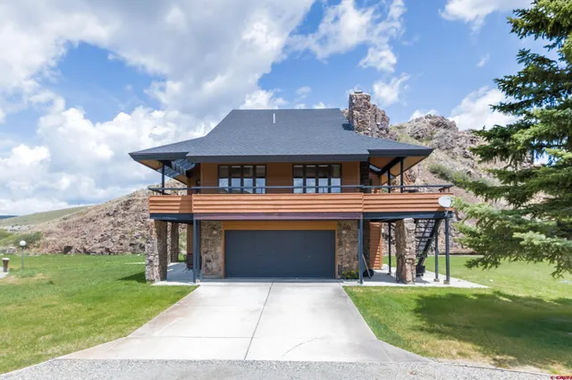 a view of a cafe with a large window and a yard with plants and a large tree