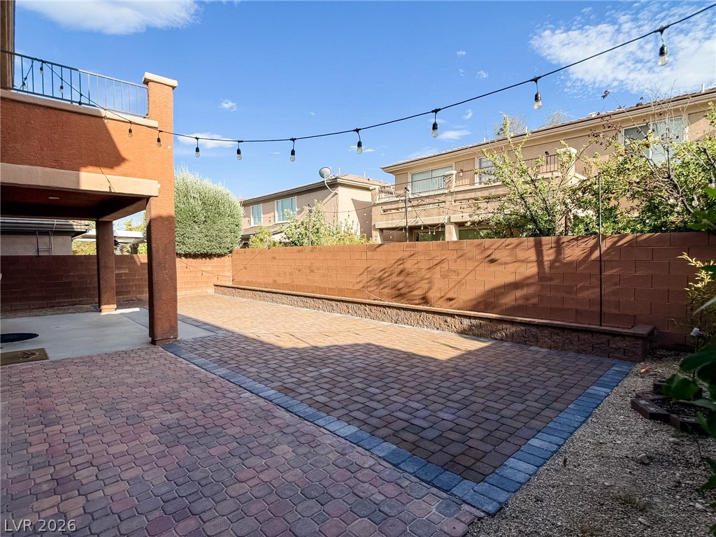 8683 Moreno Mountain Avenue Las Vegas, NV 89178 - Photo 24 of 26 An inviting backyard oasis features durable paver flooring and string lighting, perfect for evening gatherings.