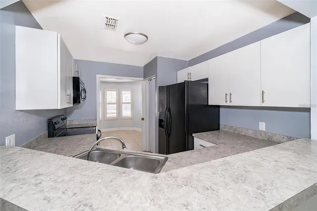 a view of a kitchen with a sink dishwasher refrigerator and a stove top oven