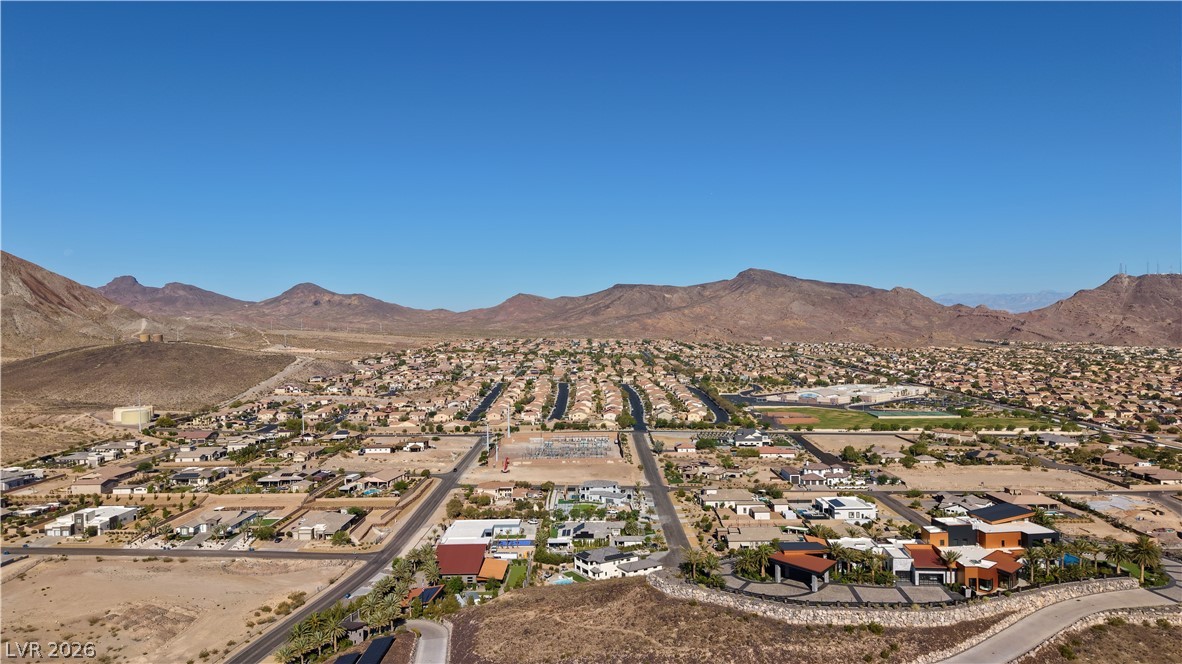 1243 Gloria Mountain Road Henderson, NV 89002 - Photo 6 of 12 A sweeping aerial perspective reveals a vast neighborhood nestled at the foot of desert mountains.