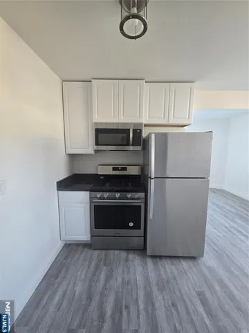 a kitchen with a refrigerator and a stove top oven