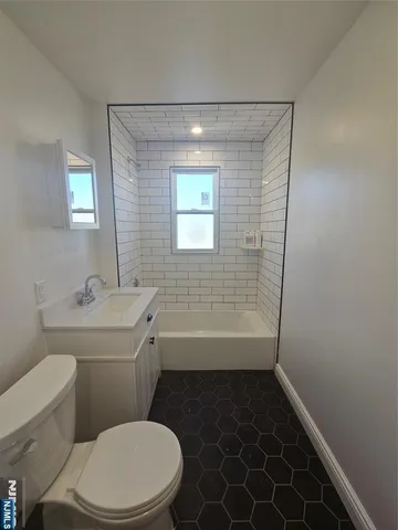 a bathroom with a sink a toilet a window and vanity