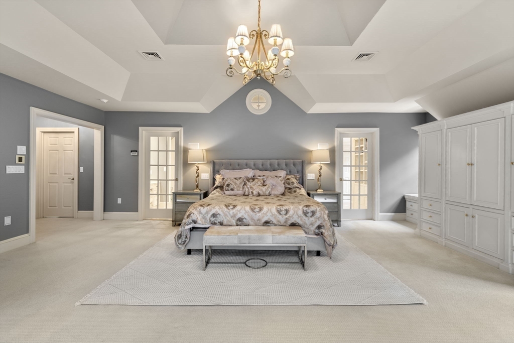 137 Lake Street Sherborn, MA 01770 - Photo 14 of 42 a spacious bedroom with a bed and a chandelier