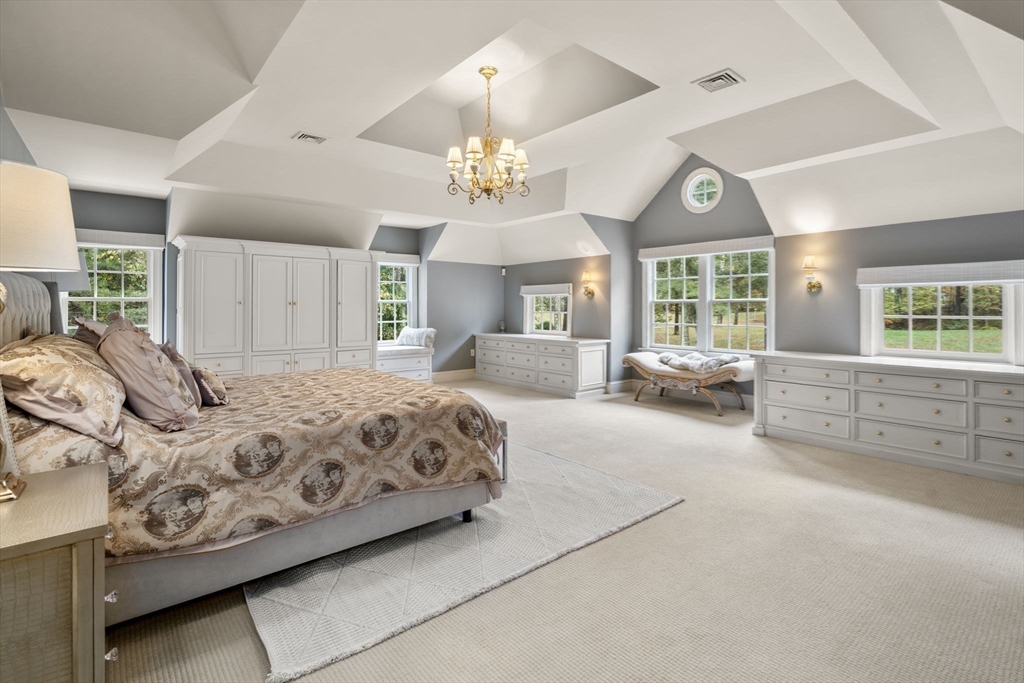 137 Lake Street Sherborn, MA 01770 - Photo 15 of 42 a spacious bedroom with a large bed and a chandelier