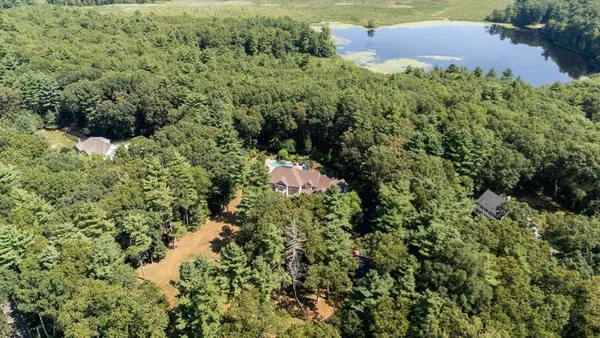 an aerial view of residential house with outdoor space and trees all around